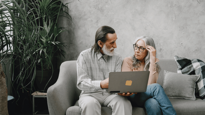 Man explaining one of the common Retirement Planning Mistakes to his concerned wife while reviewing documents.